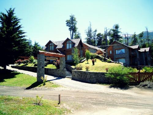 a large house with a fence and a house at Hosteria Patagon in Villa La Angostura