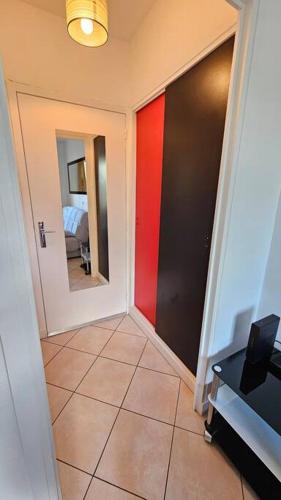 a hallway with a red and black door and a bedroom at Le Renoux #Thermes#Confort in Royat