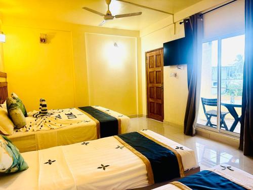 a hotel room with two beds and a balcony at Sorenzo Maldives in Thoddoo