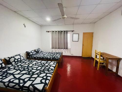 a room with two beds and a table in it at EESTEE Mount in Watumulla