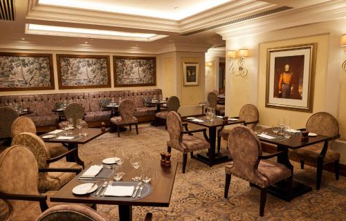 a restaurant with tables and chairs in a room at The Royal Horseguards Hotel, London in London