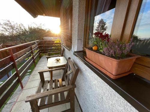 a balcony with a bench and a flower pot on a window at Chatička Lukov in Lukov