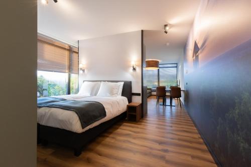 a bedroom with a bed and a table and chairs at Longstay Achterhoek in Zeddam
