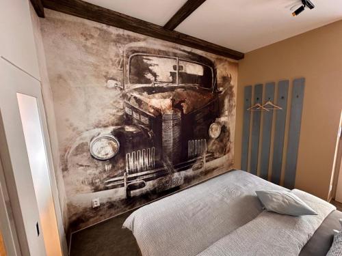 a bedroom with a painting of a truck on the wall at Ateliér Kráľovič in Hokovce