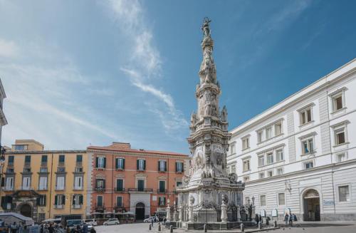 a monument in a square in front of a building at Munaciello Rooms in Naples