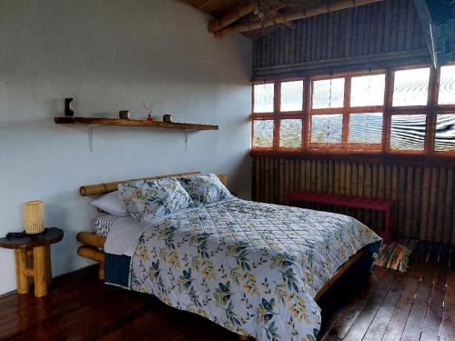 a bedroom with a bed in a room with windows at Cabaña Mirador Calima in Mediacanoa