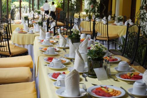 a long table with plates of food on it at Hotel Hacienda Los Laureles in Oaxaca City