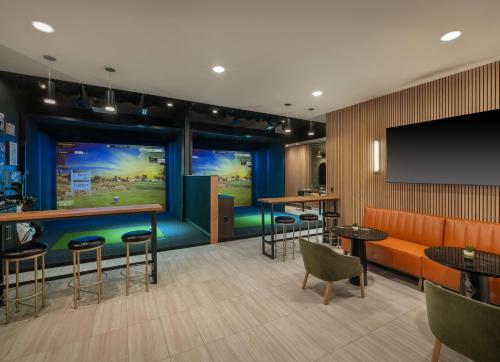 a hotel room with a bar and a flat screen tv at Hilton Indianapolis Hotel & Suites in Indianapolis