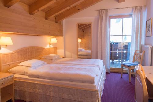 Un dormitorio con una cama grande y una ventana en Das Bürstegg, en Lech am Arlberg