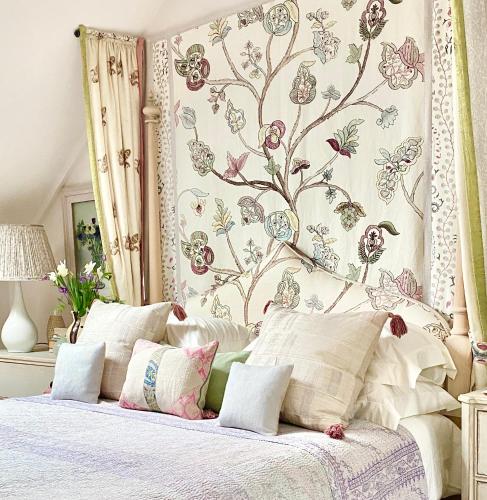 a bedroom with a bed with a floral wall at Angel Yard in Woodstock