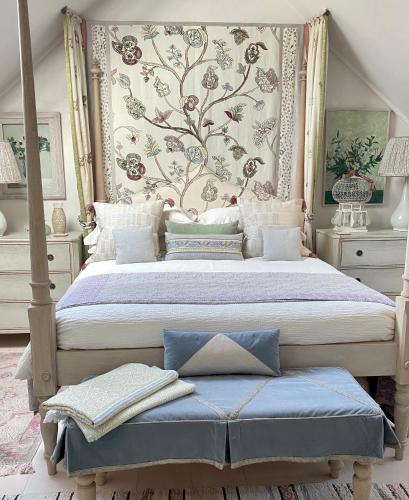 a bedroom with a large bed with a floral wall at Angel Yard in Woodstock