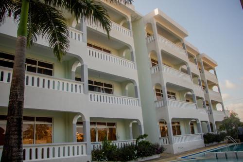a large white building with a palm tree at Nightingale Apartments Hotel Mombasa in Shanzu