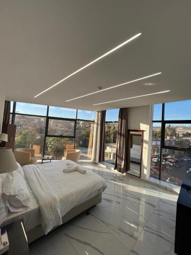 a large bedroom with a bed and large windows at Jerash Hotel in Jerash