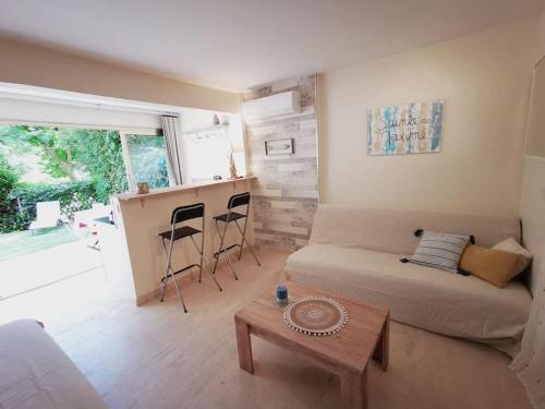un salon avec un canapé et une table dans l'établissement Studio rez de jardin à Sainte-Maxime, à Sainte-Maxime