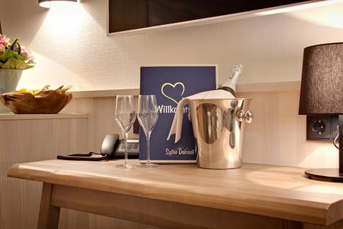 a counter with a bottle of wine and glasses on it at Sylter Domizil in Wenningstedt
