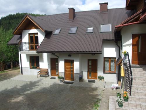 a large white house with a brown roof at Pokoje i apartamenty pod Jaworzyną w Koninkach in Koninki
