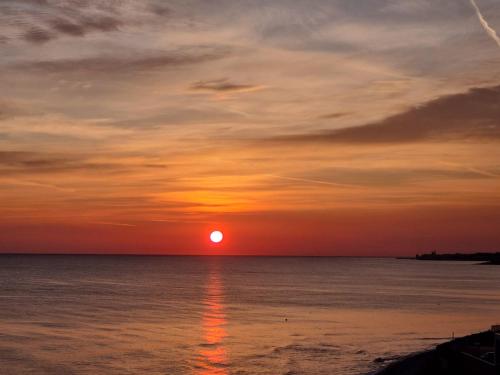 a sunset over the ocean with the sun in the sky at Seafront Holidays & Workstays in Molfetta