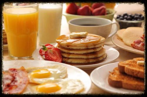 een tafel met borden vol ontbijtproducten en drankjes bij Rock Cottage, Bela-Bela in Bela-Bela