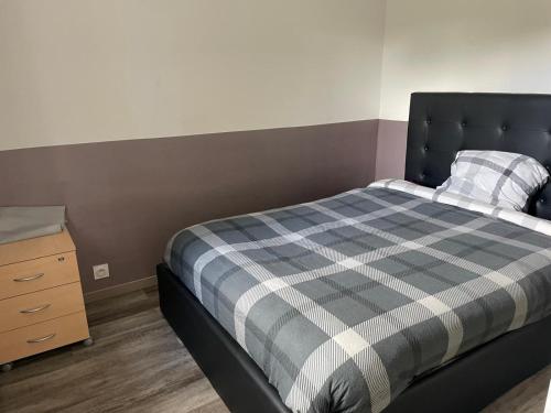 una piccola camera da letto con un letto e una cassettiera di Petite maison cosy au fond du jardin a Belle-Église