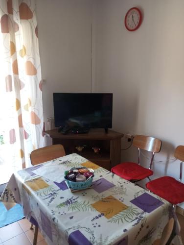 une table de salle à manger avec un bol de fruits dessus dans l'établissement F1 chambre et cuisine, à Reynès