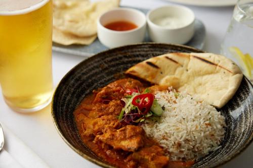 a plate of food with rice and bread and a drink at The Royal Horseguards Hotel, London in London