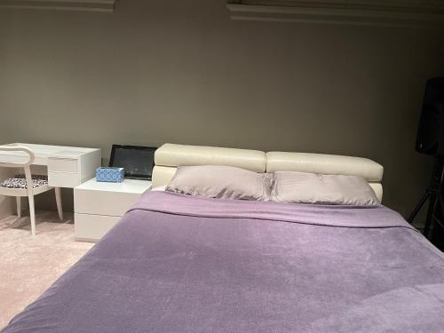 a bedroom with a bed with purple sheets and a desk at Campus Haven in Vancouver