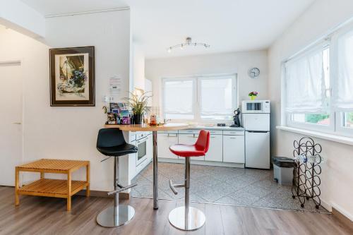 une cuisine avec une table, deux chaises et un comptoir dans l'établissement AML - Atelier Musique Lutherie - Appt 20 min de Metz, à Gandrange