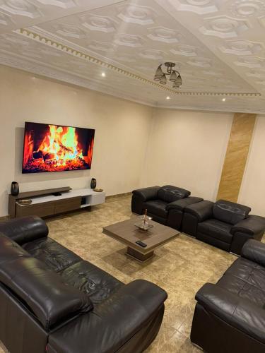 a living room with leather furniture and a flat screen tv at Seven suite in Brazzaville
