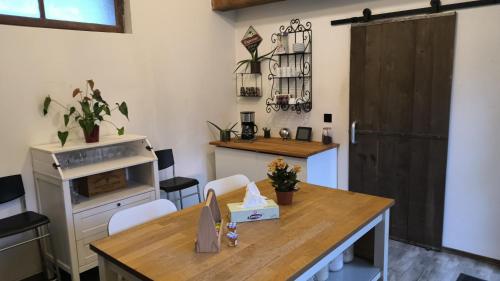 Il comprend une cuisine avec une table et une porte en bois. dans l'établissement Maison de village, à Villeroy