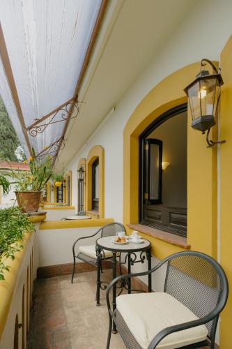 a balcony with chairs and a table and a window at Hotel Hacienda Los Laureles in Oaxaca City