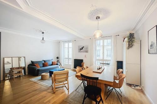 un salon avec une table et un canapé bleu dans l'établissement Spacious apartment near Gare du Nord and Est, à Paris