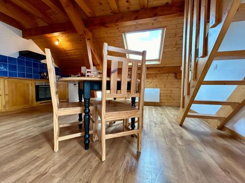 une cuisine avec une table et des chaises dans une pièce dans l'établissement Chez Fred 202 - Parking Wifi - CLG Savoie, à Saint-Pierre-dʼAlbigny
