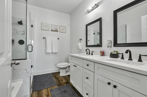 Un baño blanco con inodoro y lavabo. en Luxury NOLA 6 Bedroom Oasis, en Nueva Orleans