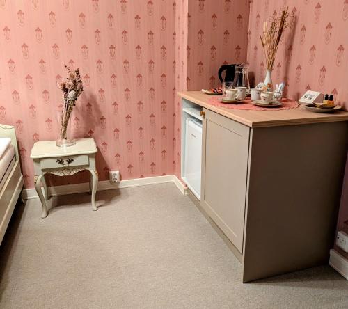 a small kitchen with pink wallpaper and a table at Rauhalahden Kartano in Kuopio