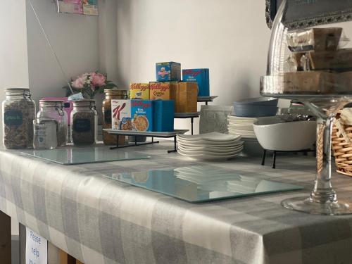 a table with a glass counter top with plates at The Butterfly Guest House in Porthcawl
