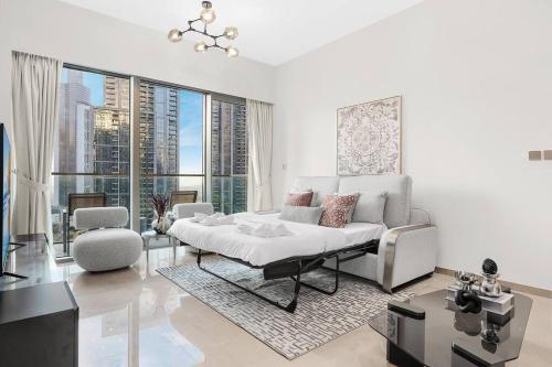ein Wohnzimmer mit einem Bett und einem großen Fenster in der Unterkunft FIRST CLASS 1BR Charming City View in Dubai