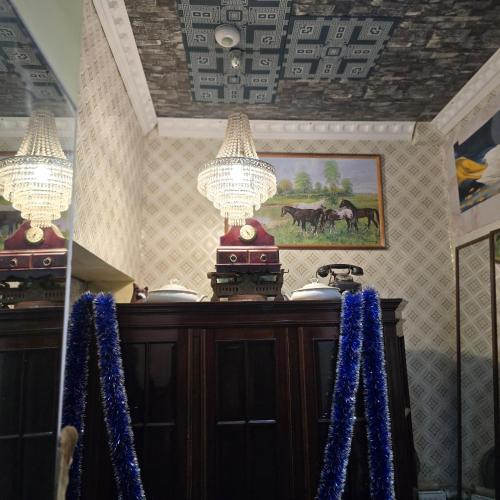 a room with two chandeliers above a wooden cabinet at Hostel Apollo in Ząbkowice Śląskie