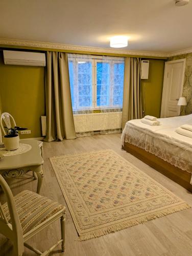 a bedroom with a bed and a chair and a window at Rauhalahden Kartano in Kuopio