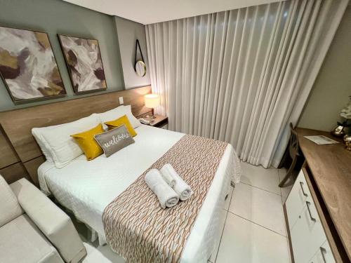 a bedroom with a bed with two towels on it at Flat Completo Granja Brasil in Petrópolis