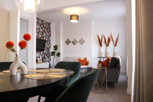 a living room with a table and green chairs at Top Spot 2-Bed Spacious Apartment Town Centre Train Station WIFI in Colchester