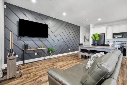 a living room with a couch and a television on a wall at Charming NOLA Oasis in New Orleans