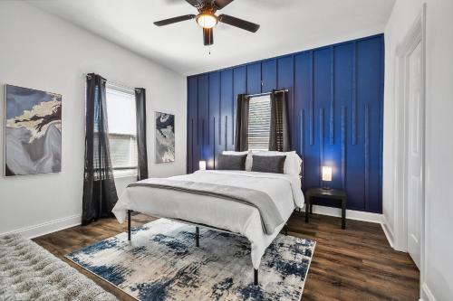 a bedroom with a bed and a blue wall at Charming NOLA Oasis in New Orleans