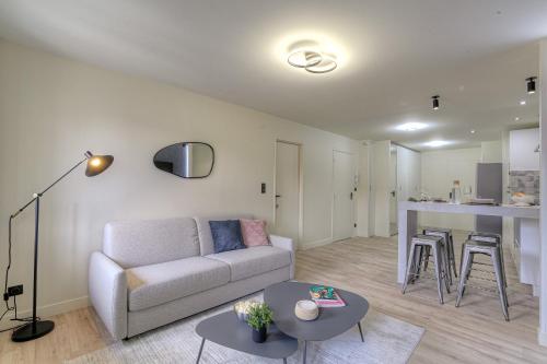 un salon avec un canapé et une table dans l'établissement Le choix de Jeanne, T2 lumineux confortable, à Vienne