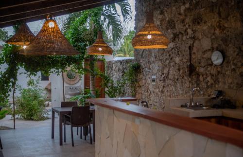 a kitchen with a bar with a sink and pendant lights at Casa Cactus Buenavista in Bacalar