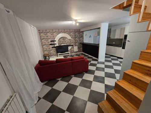 - un salon avec un canapé rouge et un sol en damier dans l'établissement maison de vacances proche blaye, à Mazion
