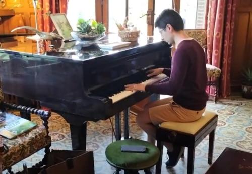 a man playing a piano in a living room at Domaine des Thomins in Cisai-Saint-Aubin