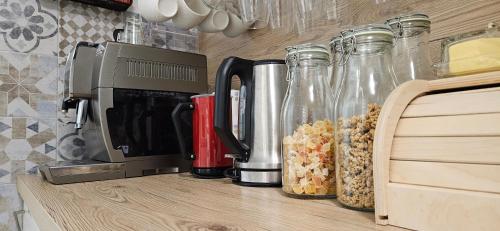 a kitchen counter with a coffee maker and glass bottles at Hotel Elvezia - Self Check-in in Lavorgo