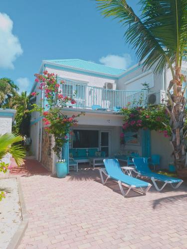 a house with two blue chairs and a balcony at Villas on Great Bay VILLA FOXIE in Philipsburg