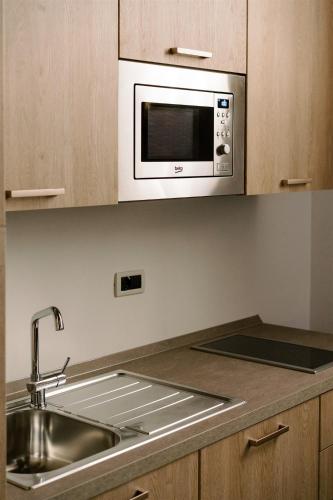 a kitchen with a sink and a microwave at Residence Carlton in Ferrara
