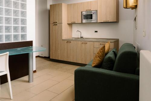 a living room with a couch and a kitchen at Residence Carlton in Ferrara